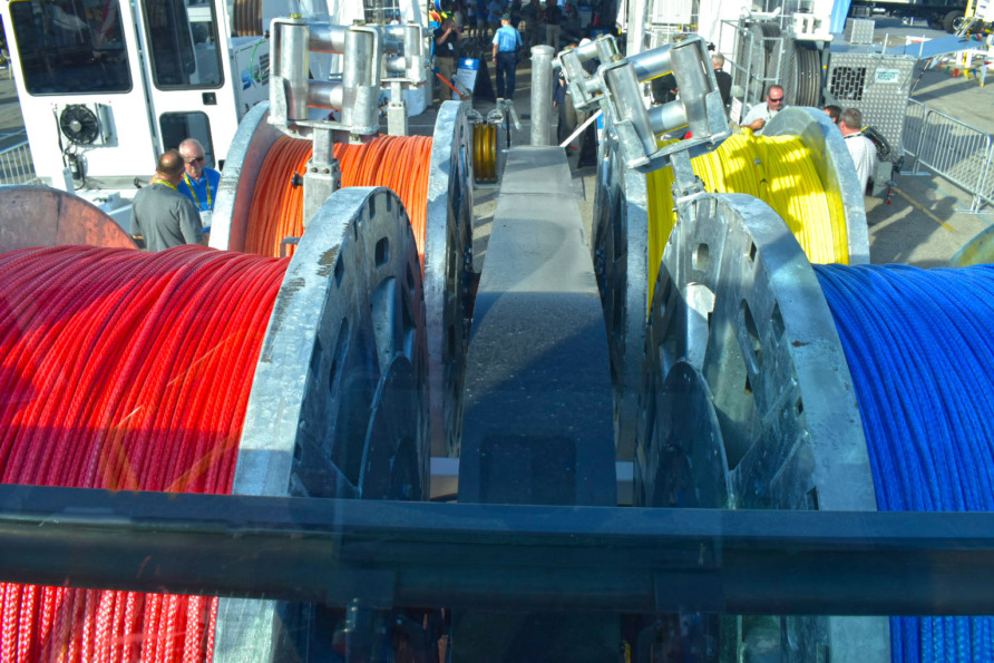 Colorful industrial cables wound on large metal spools in an outdoor setting.