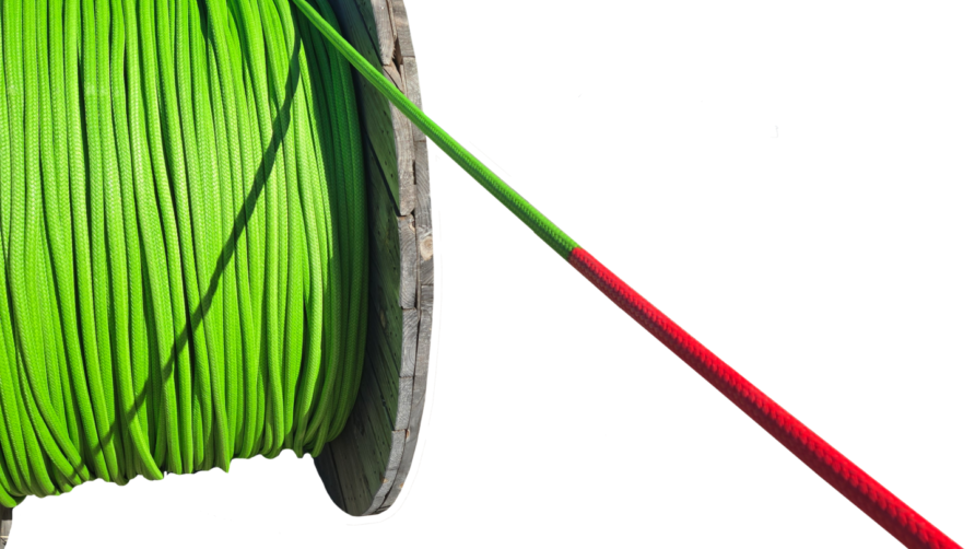 Spool of bright green cable with a section of red-taped end, used for electrical or network installations.